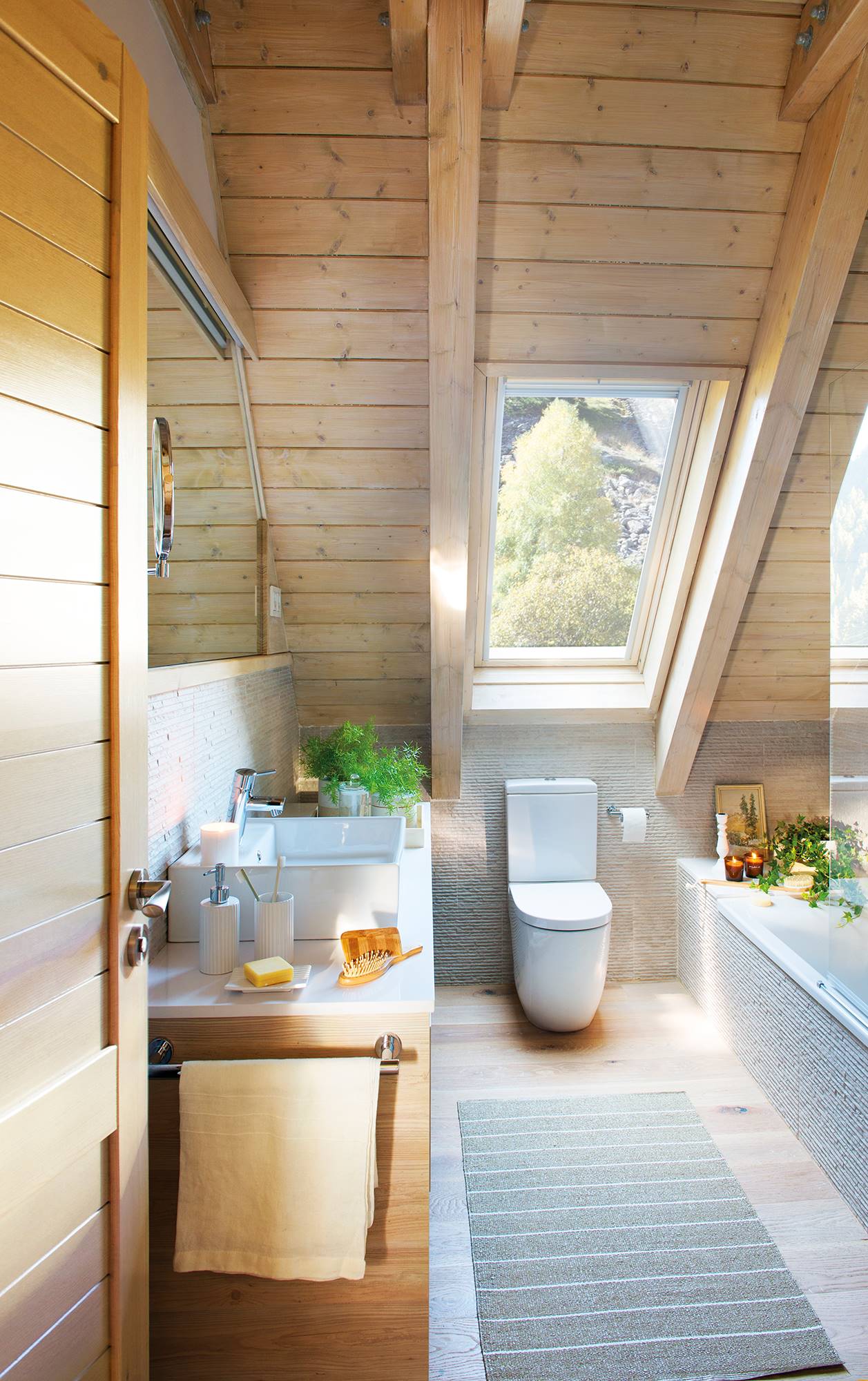 Baño rústico en buhardilla con techo y pavimento de madera.