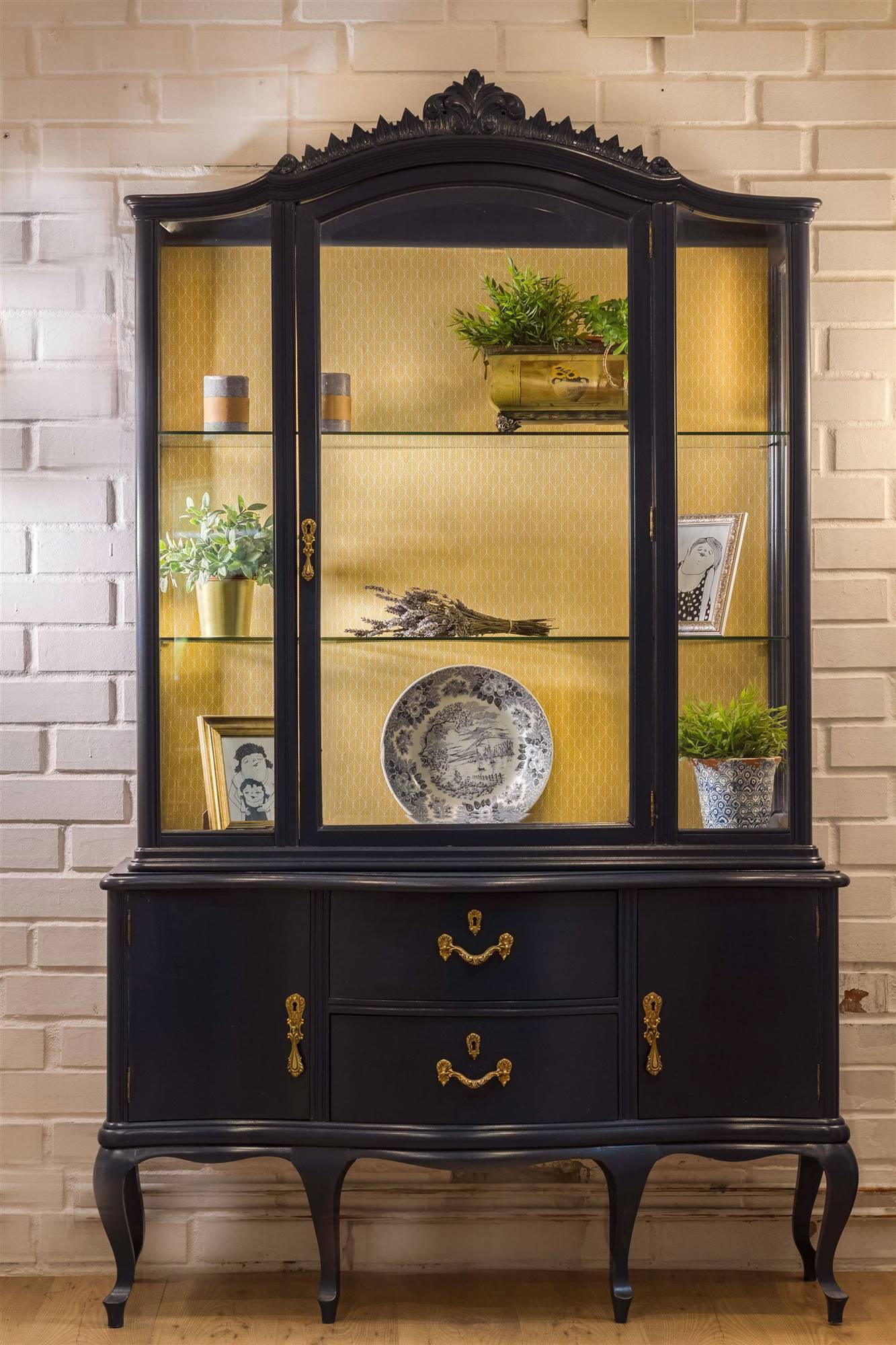 Vitrina clásica pintada en azul intenso y decorada con tapiz amarillo