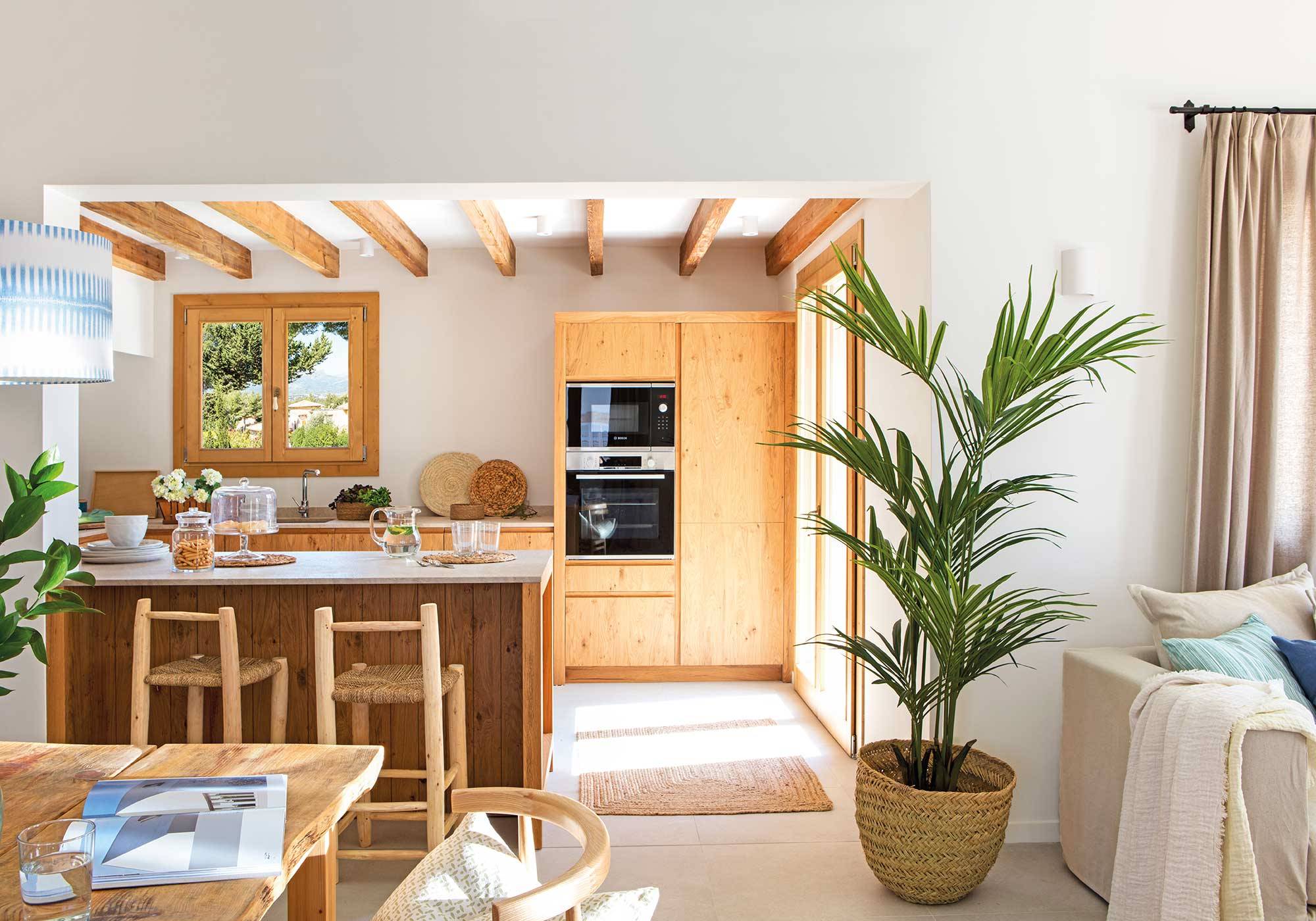 Cocina abierta de estilo rústico econ mobiliario de madera y barra.
