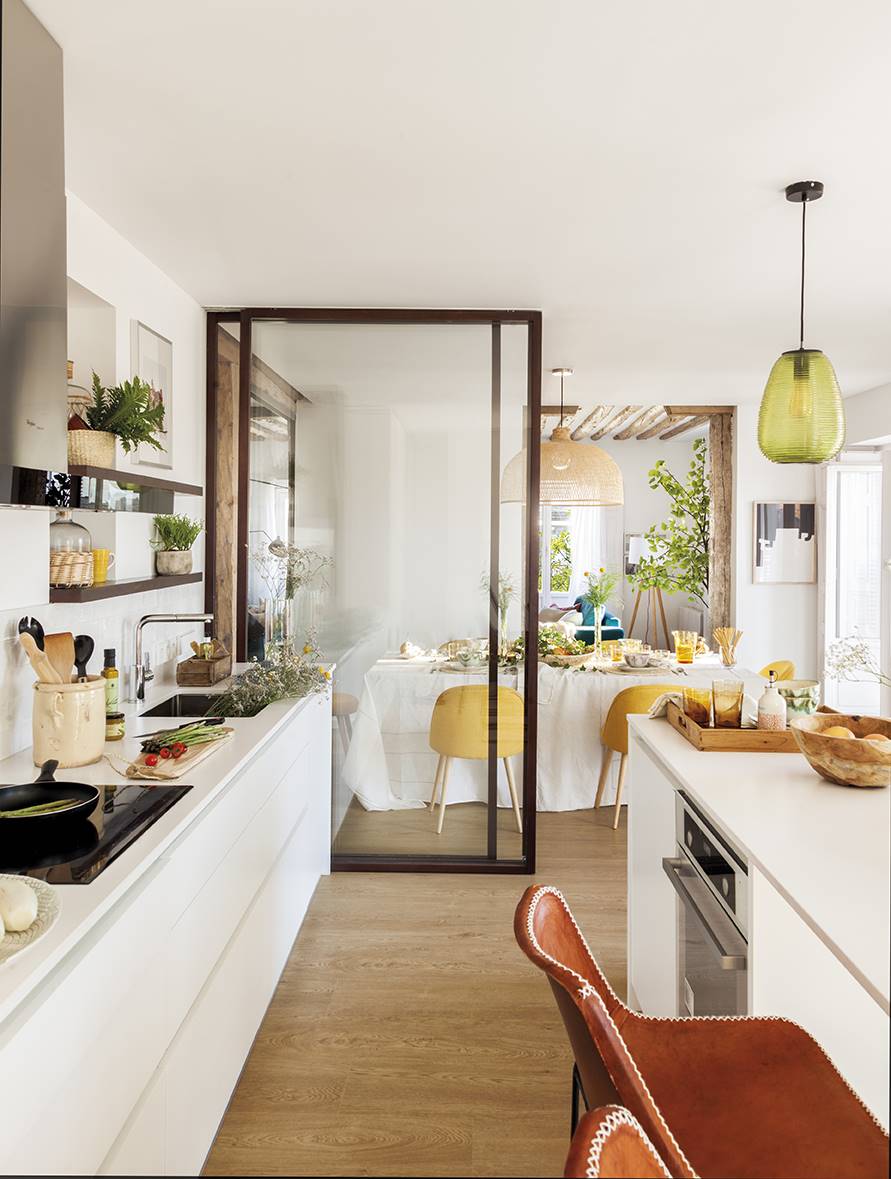 Cocina abierta y moderna con pared semiabierta de cristal y corredera.