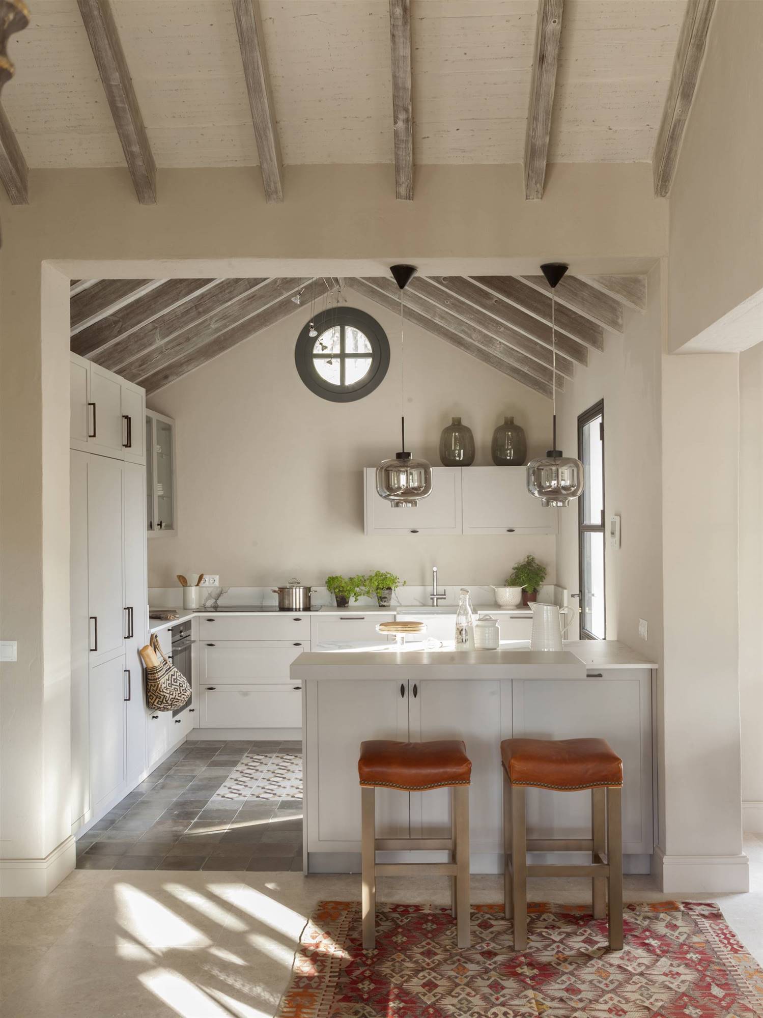 Cocina abierta con armarios blancos y diferentes tiradores.