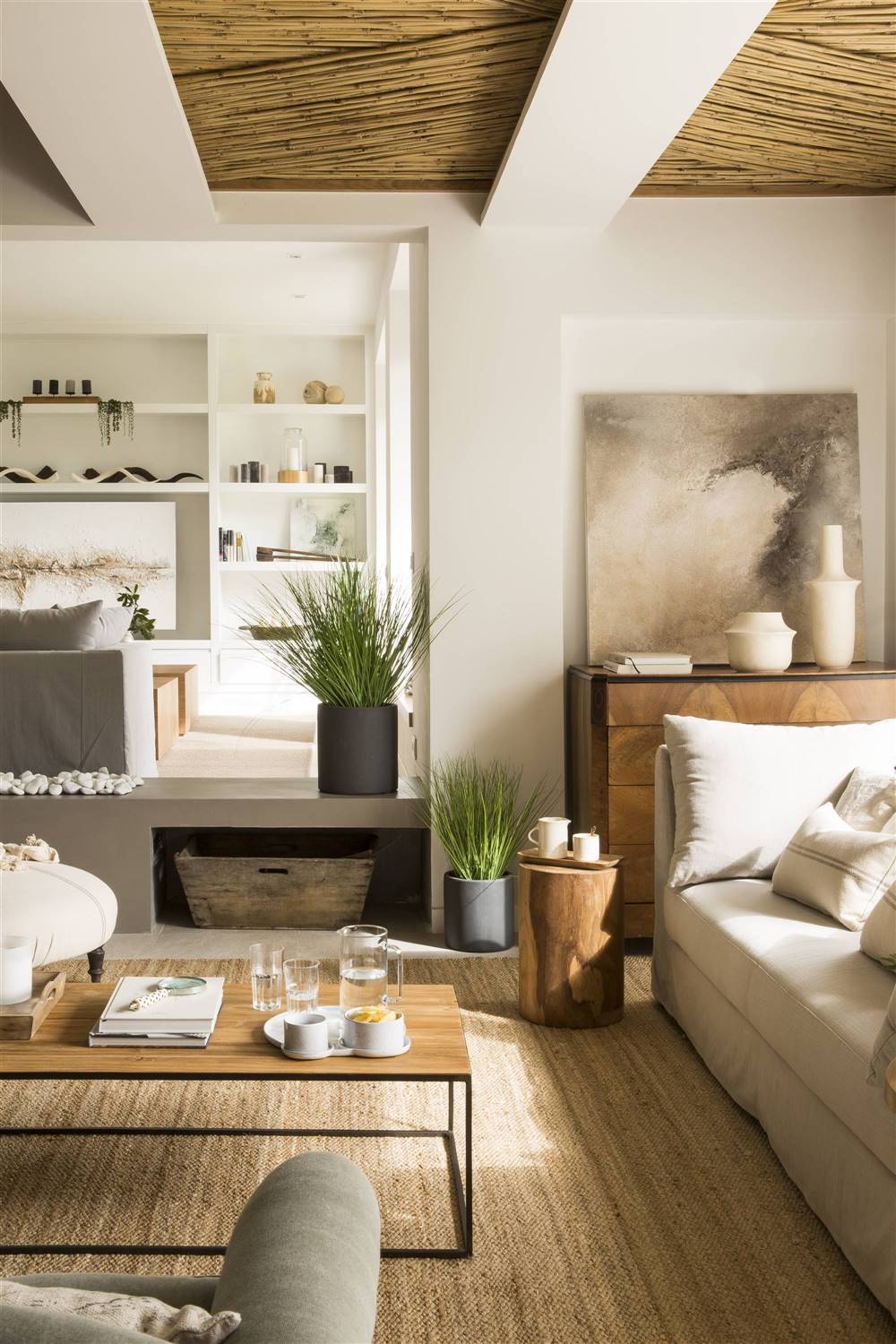 Salón con co´moda de madera con cuadro apoyado. 