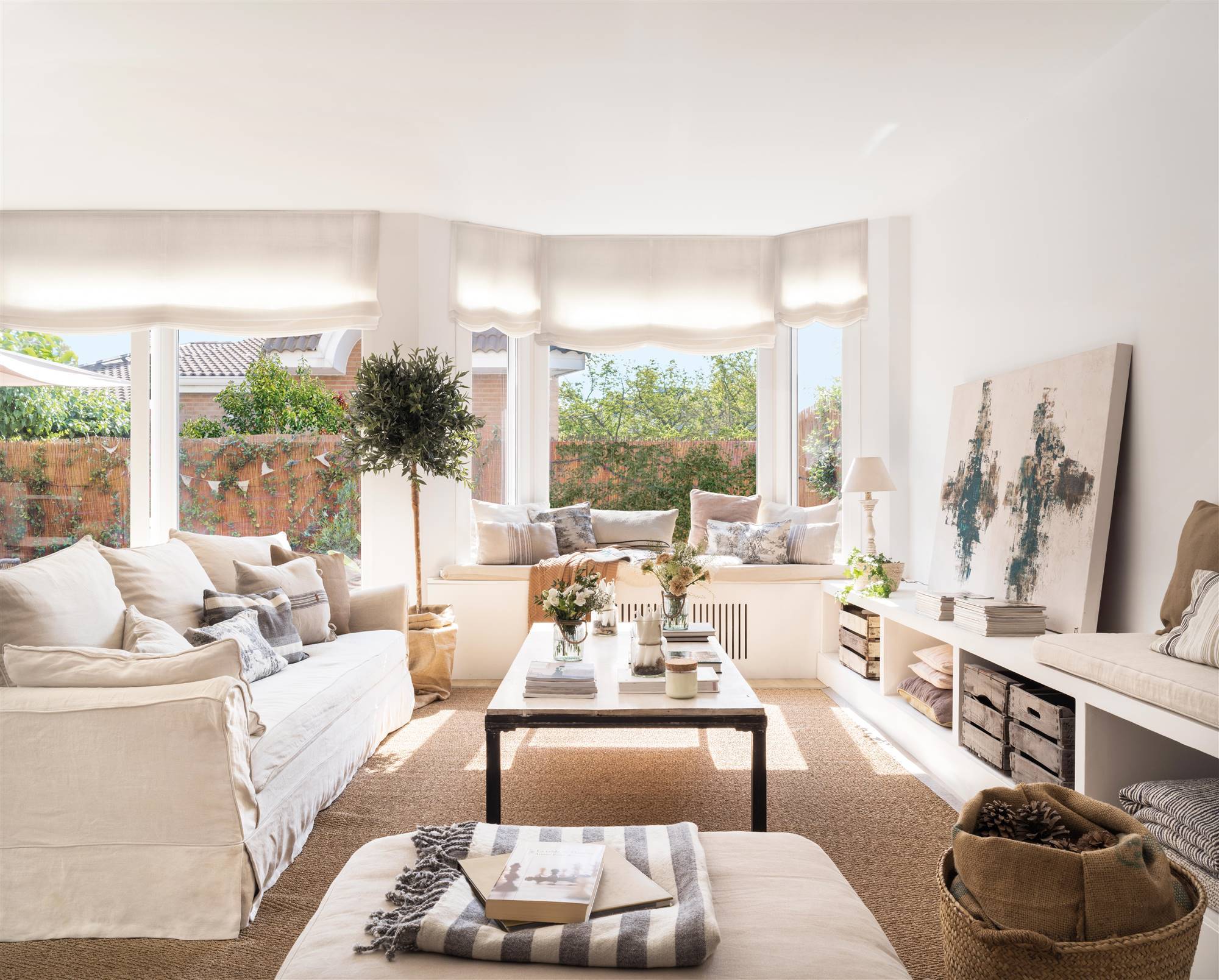 Salón decorado por Asun Antó con sofás beige y mueble de tv en blanco.