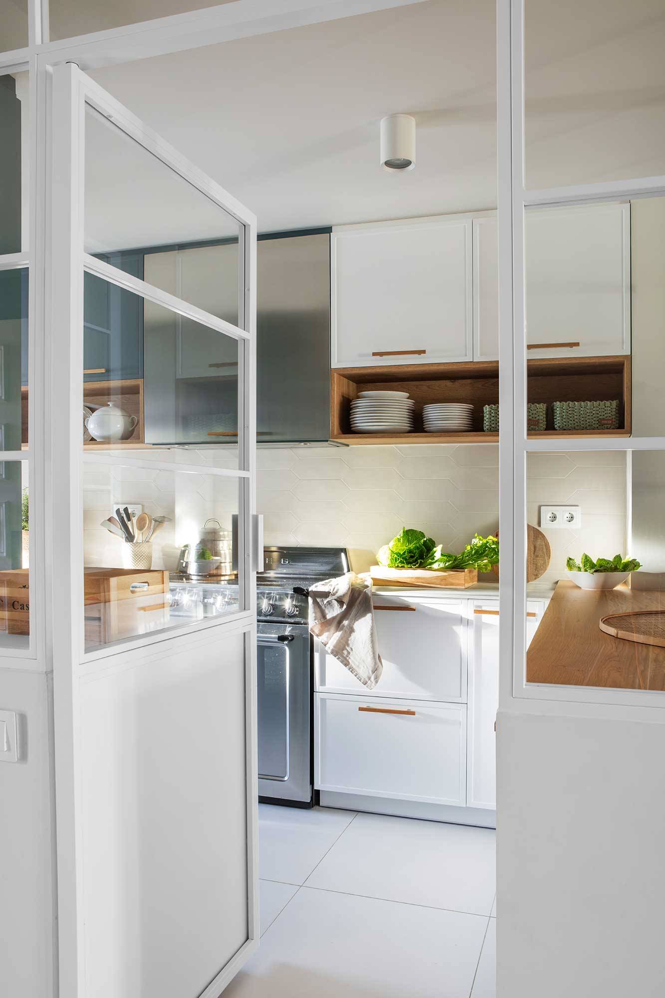Cocina con puerta acristalada y muebles en gris y blanco. 