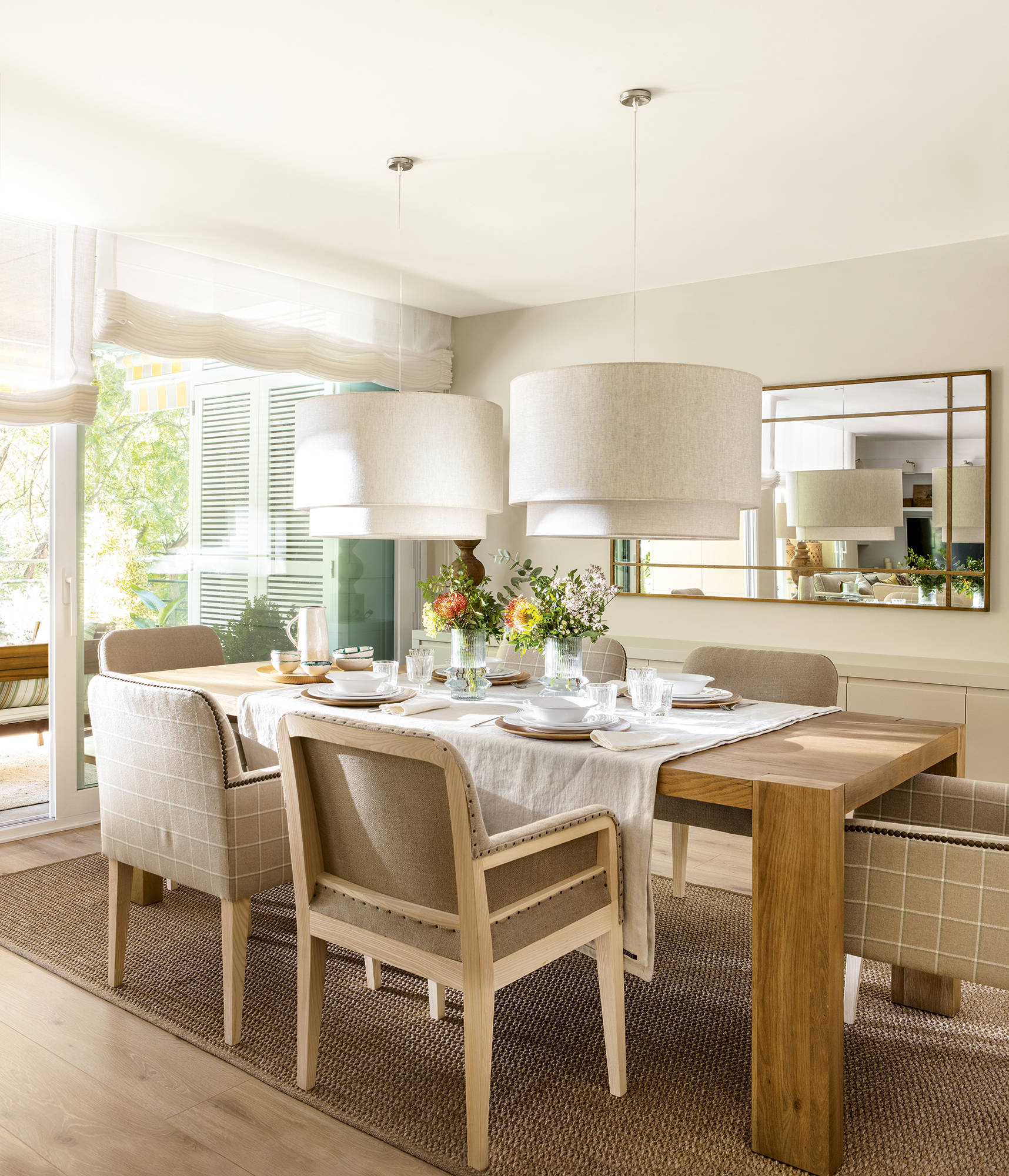 Comedor abierto al salo´n con mesa de madera y sillas tapizadas de Coton et Bois