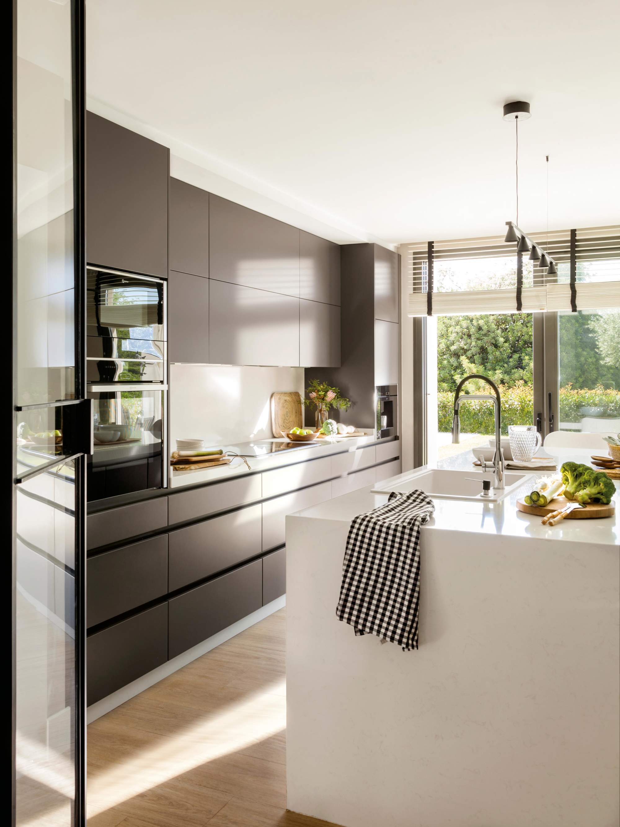 Cocina con muebles en negro e isla blanca. 