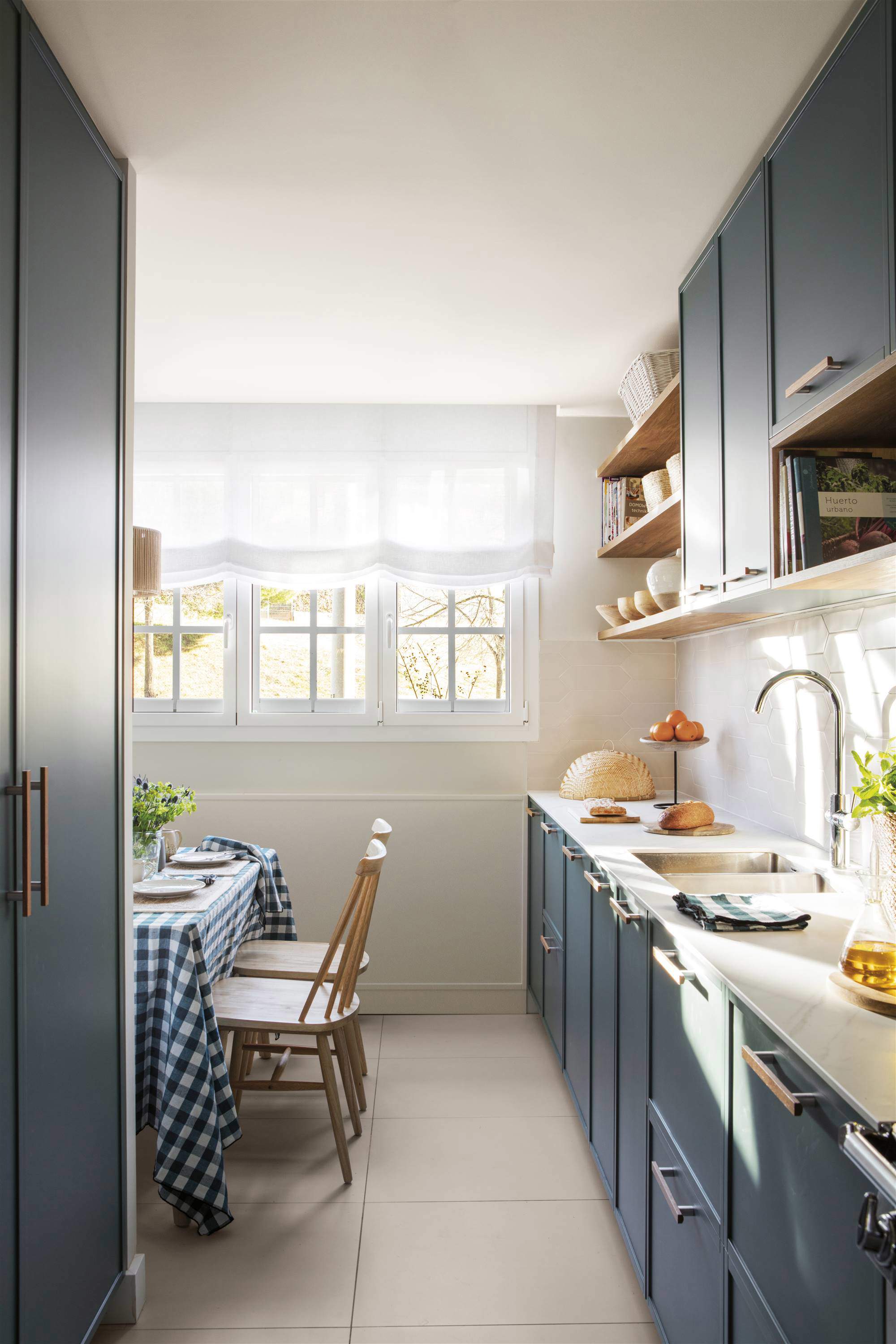 Cocina moderna azul con encimera blanca.