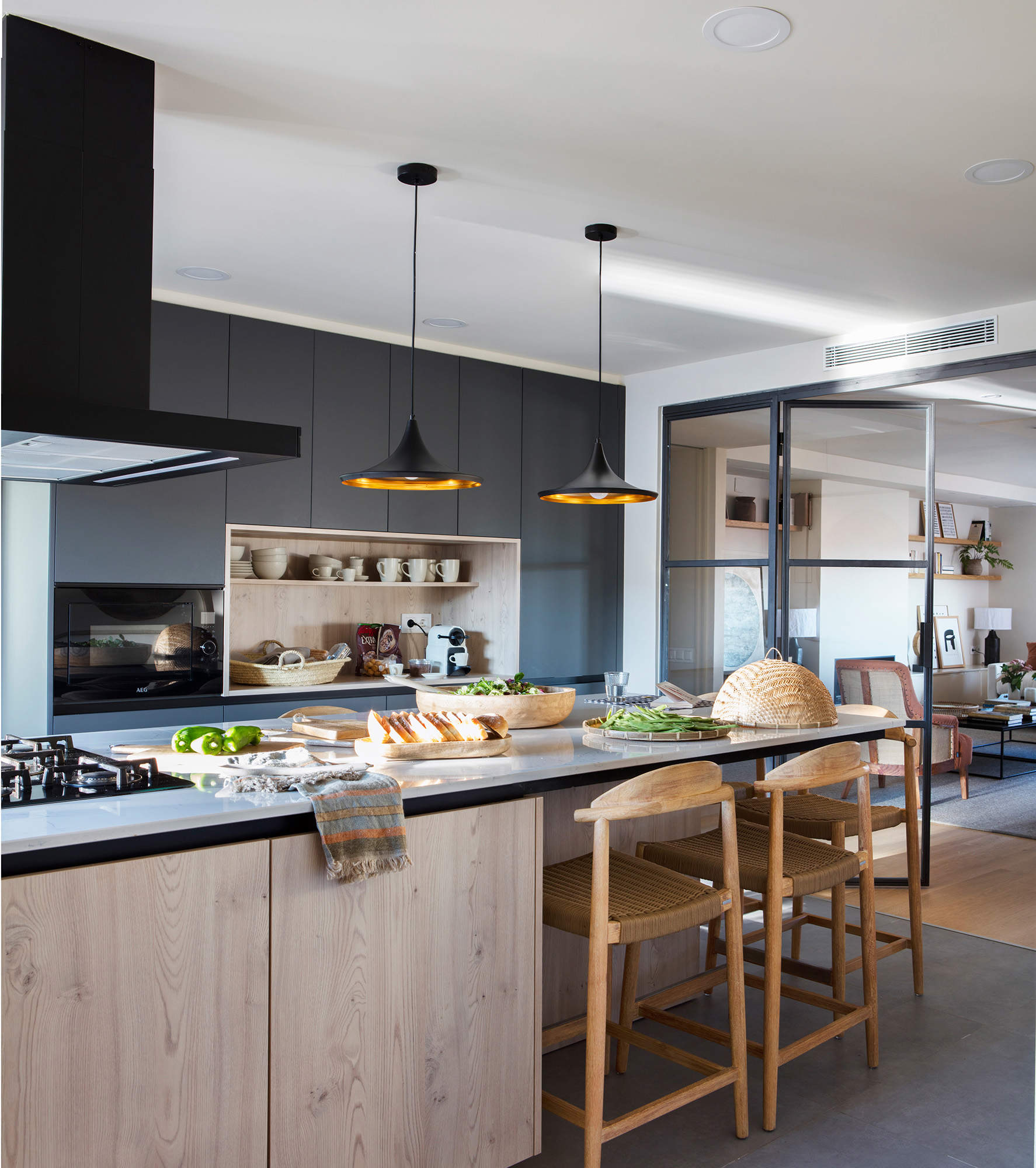 Cocina moderna con isla central y lámparas colgantes encima